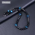 Detalle de cuentas de obsidiana, ojo de tigre azul y hematita sobre fondo de cuero negro - Ojo de Tigre Azul + Piedra Magnética + Obsidiana