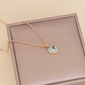 Close-up of light blue heart zircon necklace with white diamond halo on a display box - Light Blue