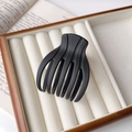 Détail d'une pince à cheveux en résine noir mat placée dans un coffret à bijoux épuré - Noir mat