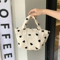 Close-up of heart pattern canvas tote bag with textured fabric and woven label detail - Handbag Lunch Bag