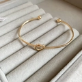Exaggerated gold cuff bracelet with center knot design and smooth round ball ends - Gold Love Knot Open Style