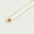 Elegant gold chain necklace featuring a round pendant set with pavé red crystals - Rose Red
