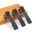 Three black ribbon-wrapped metal alligator hair clips displayed on a wooden comb handle - 5CM Ribbon Wrapped Clip / Black