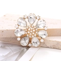 Detailed close-up of a golden alloy flower shoe charm with crystal rhinestones - White