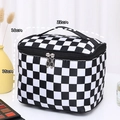 Detail view of large checkered travel toiletry bag with top handle and double zippers - Black and White Plaid