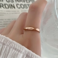 Nahaufnahme Roségold-Ring mit Je t'aime Gravur und gedrehtem Design am Finger eines Models - US 5 / Roségold