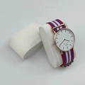 White dial watch with rose gold case on a white pillow with red and blue nylon strap - Off-White Velvet Watch Pillow