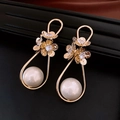 Macro-opname van gouden bloemoorbellen met sprankelende strass en witte parels - Gouden Dubbele Bloem Parel Hanger (7#)