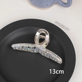 Detail view showing the 13cm iridescent laser hair claw clip on a stylish dark tray - 10# Cross-13cm
