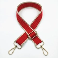 Close-up of red canvas bag strap with beige woven edges and gold metal buckles - Red