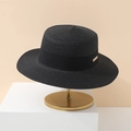 Elegant black boater hat with ribbon and gold tag on a gold minimalist display stand - Black