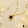 Close-up of gold chain necklace with round black gemstone pendant and white zircon halo - Black Agate