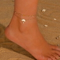 Close-up of golden double-layer anklet with lotus pendant and gems on a sunny beach - Double Layer Anklet / White