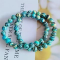 Dettaglio del bracciale a doppio giro in occhio di gatto con perle a strisce blu-verdi - Verde pavone