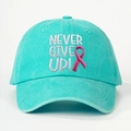 Detailed close-up of NEVER GIVE UP embroidery on a turquoise washed cotton baseball cap - Lake Blue