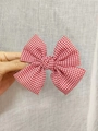 Red and white checkered satin bow hair clip held to show texture and fabric detail - Kids Duckbill Clip / Red Plaid
