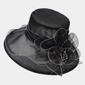 Detail of elegant black organza hat featuring mesh flower and yellow pearl beads - Black