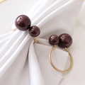 Golden Christmas napkin rings with burgundy double beads on a white cloth and plate - Red (Gold Ring)