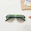 Detail of square gradient frame sunglasses with double bridge design on a wooden tray - Tea Green