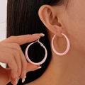 Close-up of pink oversized round hoop earrings with a matte resin finish on a model - Pink Medium Hoop