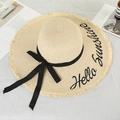 Detail of beige straw hat with Hello Sunshine embroidery and black ribbon bow - Beige Frayed Edge Hello Sunshine Embroidery