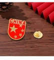 Schildförmige rote Anstecknadel mit China-Flagge, Goldsternen und CHINA-Schriftzug - CHINA Pentagramm