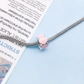 Silver snake chain bracelet with pink enamel heart bead on a blue and white background - Pink