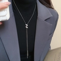 Close-up of Y-shaped silver necklace with zircon S-pendant and long metal tassels - Silver Zirconia Twisted Letter S Necklace