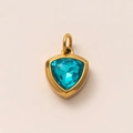 Detailed macro view of a 18k gold plated triangle pendant with a faceted blue birthstone - December Birthstone Pendant (Blue Topaz)