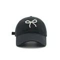 Dettaglio di un berretto da baseball in cotone nero con un fiocco di perle bianche sul davanti - M (56-58cm) / Nero