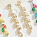 Macro shot of colorful marquise zircon leaf earrings hanging on textured white stone - Leaf White Zirconia 14K Gold Plated (ES2282)