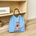 Close-up of the delicate brown bear embroidery on a light blue nylon tote bag - Blue Chubby Bear