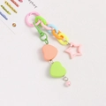 Primer plano de dijes de colores de corazón y estrella con cadenas de eslabones de plástico - Naranja y Verde