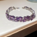 Close-up of sparkling pear-cut purple zircon stones set in a silver geometric clasp bracelet - Purple