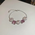 Nahaufnahme des luxuriösen silberfarbenen Armbands mit rosa Edelsteinen und Zirkon-Blumen - Armband-Silber-Rosa