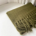 Olive green cashmere-like scarf with fringe detail, folded on a white table - Olive Green