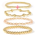 Close-up of four-piece gold bead and pink crystal bracelet set with cross charm detail - Light Pink Gold 4-Piece Set