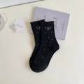 Close-up of black polka dot socks featuring frilly lace cuffs and embroidered bows - One Size / Black