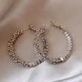 Dettaglio di orecchini a cerchio argentati con strass su sfondo di seta - 5# Cerchi in strass argento schiacciato