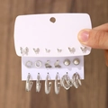 Silver geometric earring set featuring butterflies, pearls, and hoops on display card - 04 White K