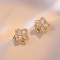 Golden flower earrings set with clear zircon on luxury champagne silk fabric backdrop - Golden Four Leaf Flower Earrings / Gold
