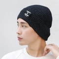 Dark grey knitted beanie featuring silver sequins and a rectangular textile patch label - Gray