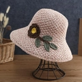 Detail of pink crochet straw hat with handmade 3D flower and green leaves on display - Pink