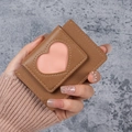 Braunes Mini-Portemonnaie mit rosa Herz-Ausschnitt aus Leder in der Hand gehalten - Braun