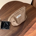 Dettaglio della trousse in maglia kaki con trama a spiga e etichetta in tessuto - Trama di spiga di riso / Cammello