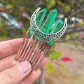 Close-up of a silver moon hair comb featuring raw green crystal pillars and metal filigree - Green + 10-Tooth Comb