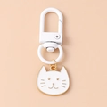 Close-up of a white cat metal keychain with a white spring hook and golden outlines - White Cat Head