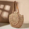 Detail einer runden Strohtasche mit braunen Ledergriffen und gewebten Blumenmustern - Camel