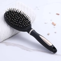 Professional black anti-static air cushion hairbrush with gold handle on marble surface - Black Oval