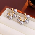 Close-up of elegant grey pearl earrings with golden base in a minimalist jewelry box - C-Shape Grey Pearl